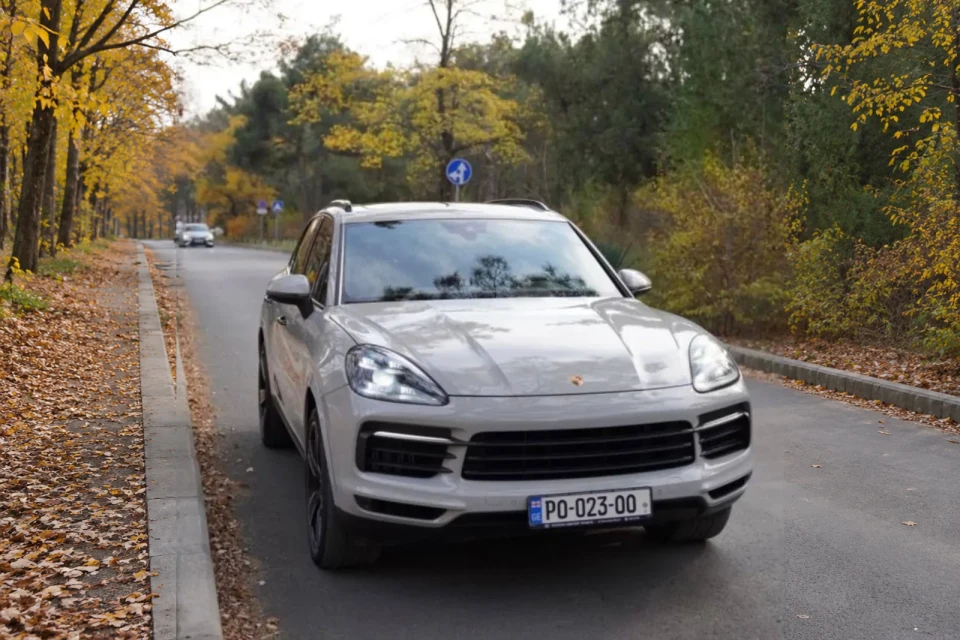 Porsche Cayenne S — вид спереди в три четверти на осенней дороге