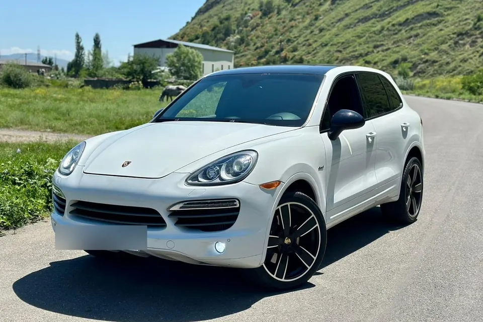 Белый Porsche Cayenne на дороге в Грузии